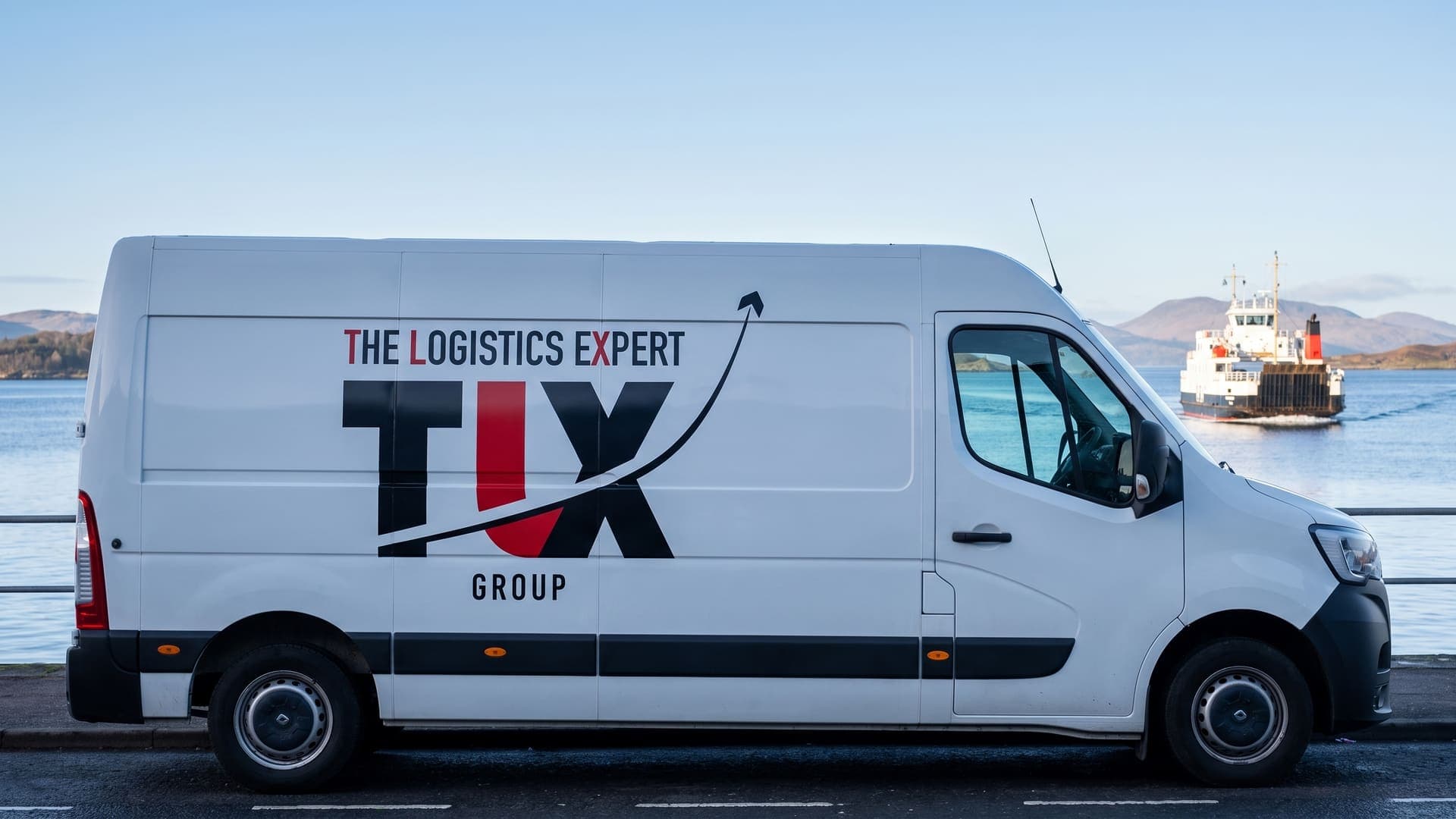 TLX Group van on the harbour front at Oban with the ferry and islands behind